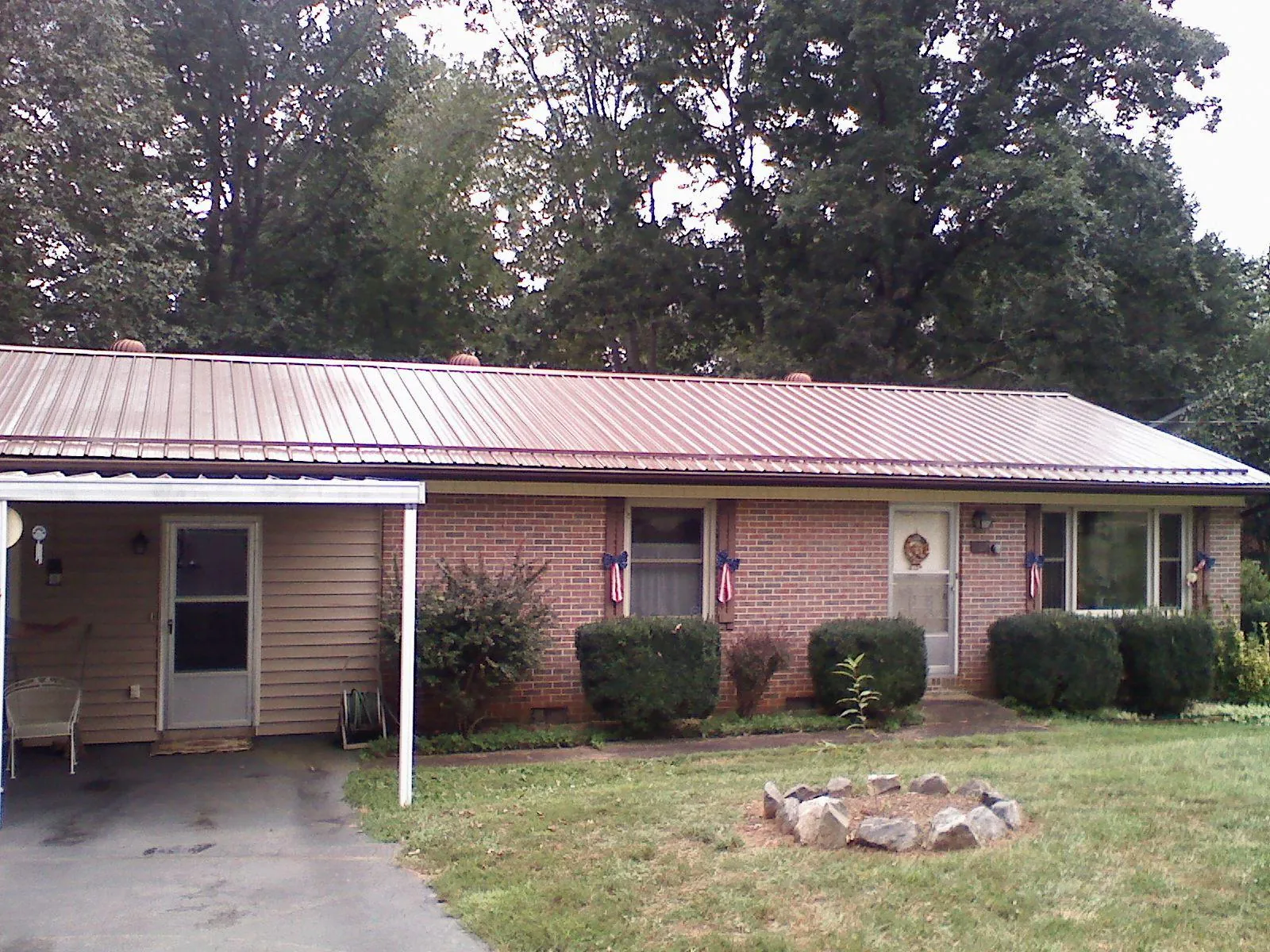 Bronze metal roof and carport on a brick ranch home — Roof Repair work by our crew in White Bluff